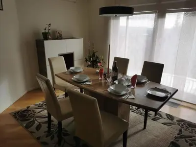 a dining room table with chairs and a table and a table at Penthouse Villa Ljubljana in Šentvid