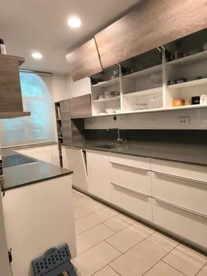 a kitchen with white cabinets and a black counter top at Penthouse Villa Ljubljana in Šentvid