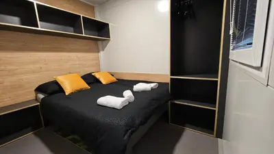 a small bedroom with a bed with towels on it at Relax Tiny House Ljubljana in Ljubljana