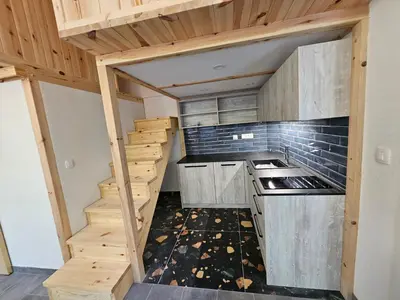 a kitchen with wooden cabinets and a staircase at Studio Masha's fairytale world in Kranjska Gora
