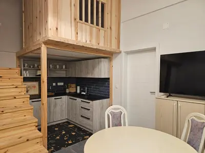 a kitchen with a table and a tv in a room at Studio Masha's fairytale world in Kranjska Gora