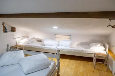 two beds in a room with white sheets and pillows at Garage Apartments in Nova Gorica