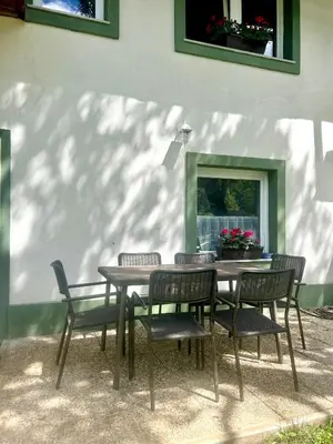 a table and chairs sitting next to a building at Bohinj Countryside House in Bohinjska Bistrica