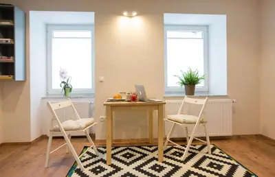 a dining room with a table and two chairs and a laptop at Castle Rock Bled apartment in Bled