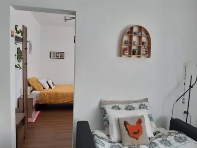 a living room with a chair and a bed at Hiša Tarka in Dobrovnik