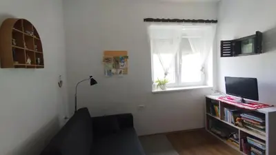 a room with a desk with a computer and a window at Hiša Tarka in Dobrovnik