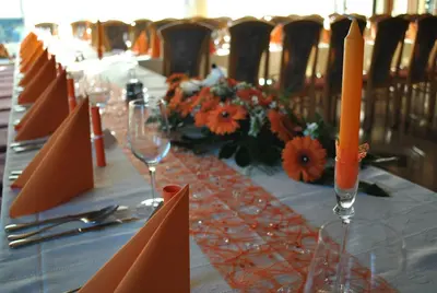 a long table with orange candles and flowers on it at Pri Vidrgarju in Vače