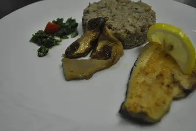a white plate of food with meat and vegetables at Pri Vidrgarju in Vače