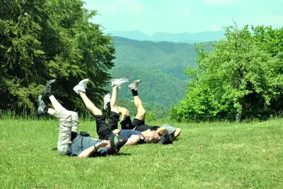 two people laying on the grass in a field at Pri Vidrgarju in Vače
