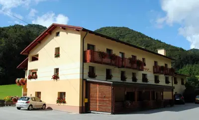 a building with a car parked in front of it at Pri Vidrgarju in Vače