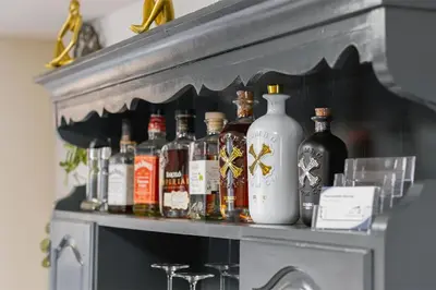 a shelf with a bunch of alcohol bottles on it at Apartma Manca in Jesenice na Dolenjskem