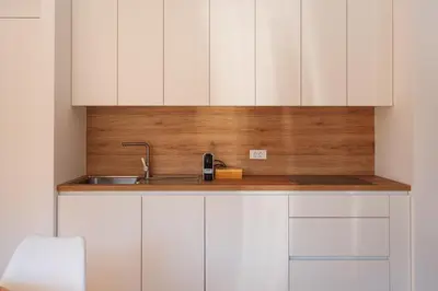 a kitchen with white cabinets and a sink at Alpine Bliss Apartment Kranjska Gora in Kranjska Gora