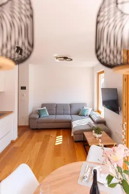 a living room with a couch and a table at Alpine Bliss Apartment Kranjska Gora in Kranjska Gora