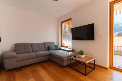 a living room with a couch and a table at Alpine Bliss Apartment Kranjska Gora in Kranjska Gora