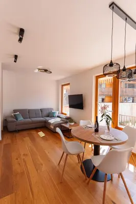 a living room with a couch and a table at Alpine Bliss Apartment Kranjska Gora in Kranjska Gora