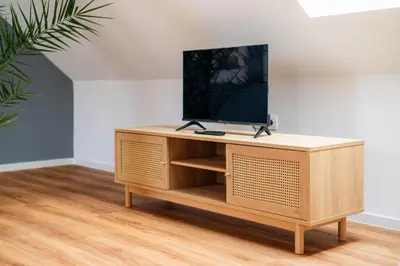 a tv on top of a wooden tv stand in a room at Apartment Berc in Bled