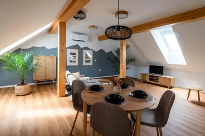 a living room with a table and chairs at Apartment Berc in Bled