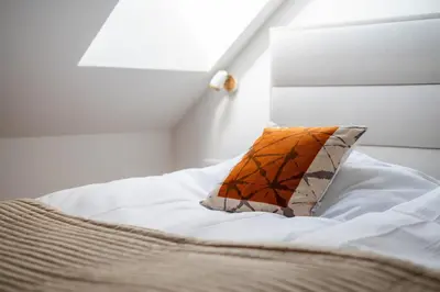 a white bed with a pillow on top of it at Apartment Berc in Bled