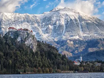 a castle on top of a mountain next to a body of water at Apartment Berc in Bled