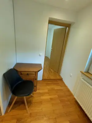 a room with a chair and a table and a mirror at GM apartma in Radovljica