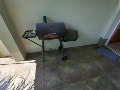 a room with a grill and a bag on a chair at GM apartma in Radovljica