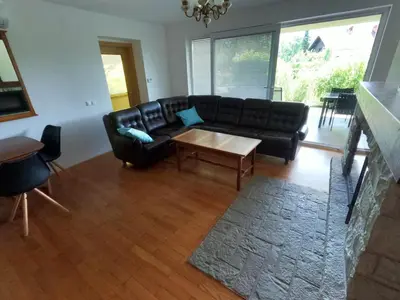 a living room with a black couch and a table at GM apartma in Radovljica