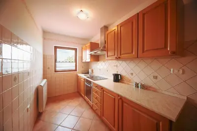 a small kitchen with wooden cabinets and a sink at Green Escape garni hotel in Postojna