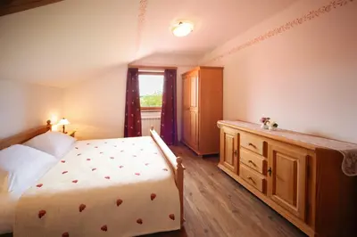 a bedroom with a bed and a dresser and a window at Green Escape garni hotel in Postojna