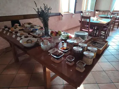 a wooden table with bowls of food on it at Green Escape garni hotel in Postojna