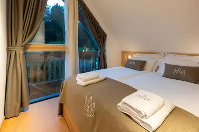 a bedroom with two beds and a large window at Chalet Bohinj Bliss Wellness and view of Triglav in Bohinj