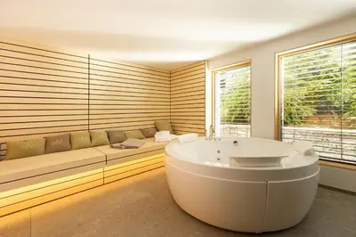 a bath room with a tub and a couch at Chalet Bohinj Bliss Wellness and view of Triglav in Bohinj
