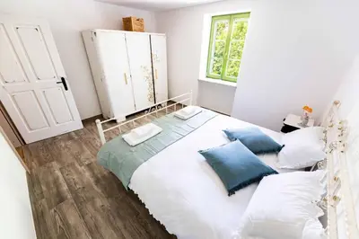 a bedroom with a bed with pillows and a window at Apartma FRIDA in Most na Soči