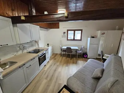a kitchen and living room with a couch and a table at Studio R in Ljubljana