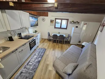 a kitchen and living room with a couch and a table at Studio R in Ljubljana