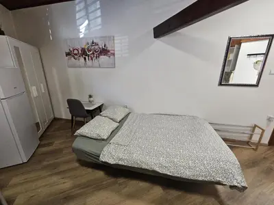 a bedroom with a bed and a table and a mirror at Studio R in Ljubljana