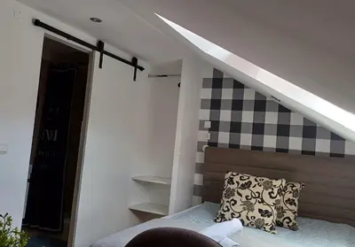 a room with a bed and a staircase with a pillow at Studio apartma ZARA in Slivnica pri Mariboru