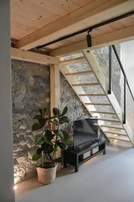 a living room with a tv and a stone wall at Viktor Estate in Deskle