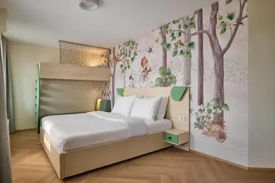 a bedroom with a bed and a mural of trees at Toplice Family Inn - Terme Čatež in Čatež ob Savi