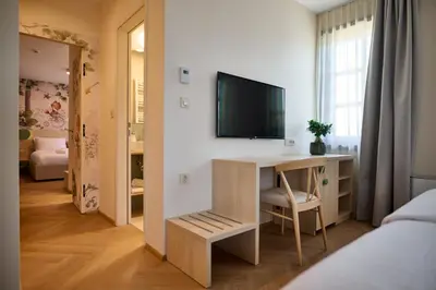 a bedroom with a desk and a television on a wall at Toplice Family Inn - Terme Čatež in Čatež ob Savi
