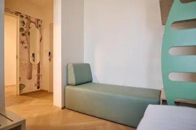 a blue chair sitting in a room with a hallway at Toplice Family Inn - Terme Čatež in Čatež ob Savi