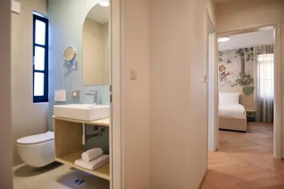 a bathroom with a sink and a toilet and a bedroom at Toplice Family Inn - Terme Čatež in Čatež ob Savi