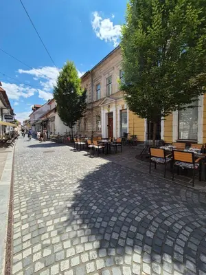 a cobblestone street with tables and chairs and a building at Ritual Studio City Center in Ljubljana
