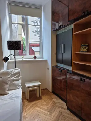 a bedroom with a bed and a dresser and a window at Ritual Studio City Center in Ljubljana