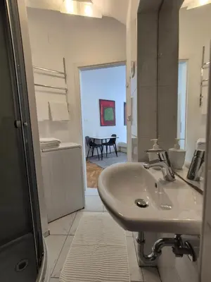 a white bathroom with a sink and a table at Ritual Studio City Center in Ljubljana