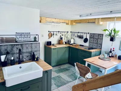 a kitchen with green cabinets and a white sink at Minicottage Casa de Lipa in Kostanjevica na Krki