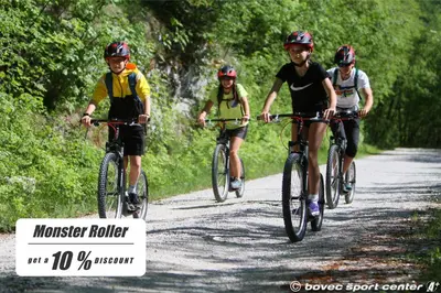 a group of people riding bikes down a dirt road at Apartments Bovec House Center in Bovec