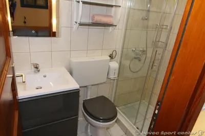 a bathroom with a shower and a toilet and a sink at Apartments Bovec House Center in Bovec