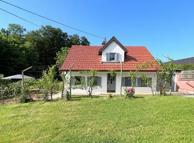 a small white house with a red roof at Maria's Orchard Cottage - Nature Retreat in Slovenia in Rogaška Slatina