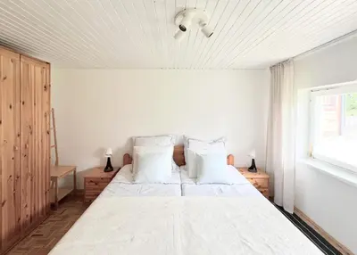 a bedroom with a bed with white sheets and pillows at Maria's Orchard Cottage - Nature Retreat in Slovenia in Rogaška Slatina