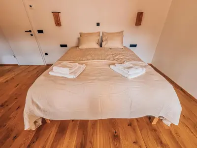 a large bed with two towels on it in a room at Maison Lenka in Rateče